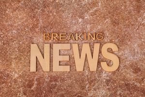 Wooden letters spell 'Breaking News' on a textured, marble-like background. Ideal for newsworthy content.
